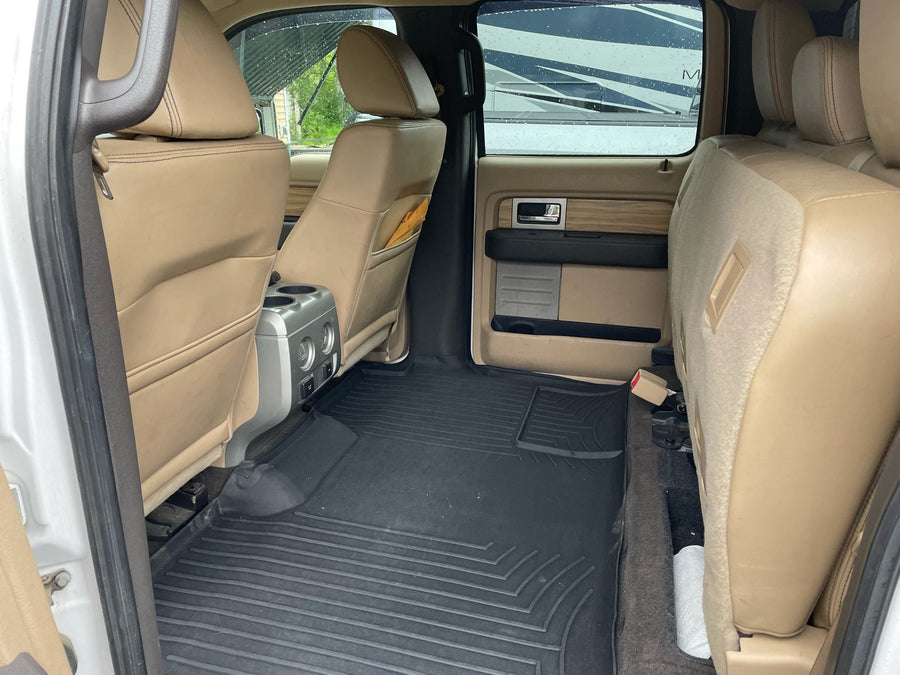 parked on wet pavement on a rainy day.|Inside a comfortable RV rental truck: view of tan interior