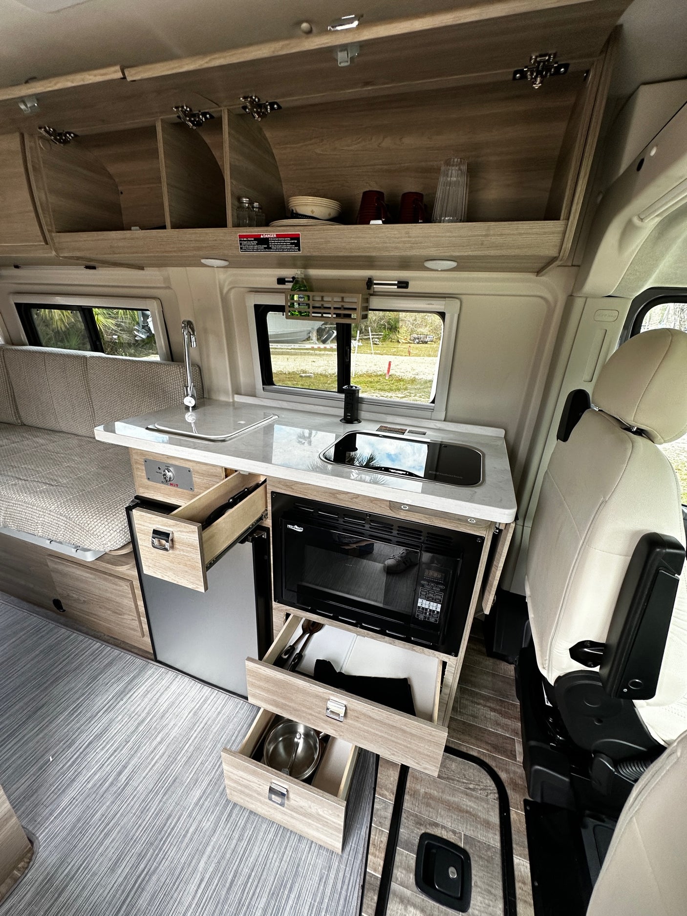 Explore this RV rental's modern interior with a compact kitchen, extensive storage, & comfortable living space.