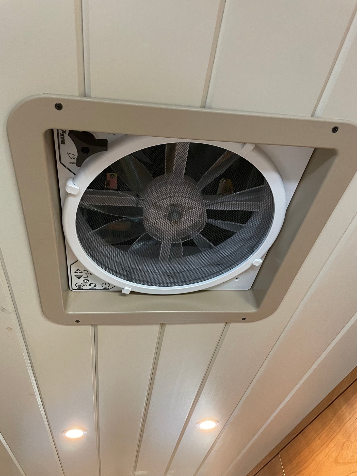 RV rental interior: A ceiling fan (MaxxAir-style) with controls (on/off, in/out, auto) and recessed lights on wood panels.