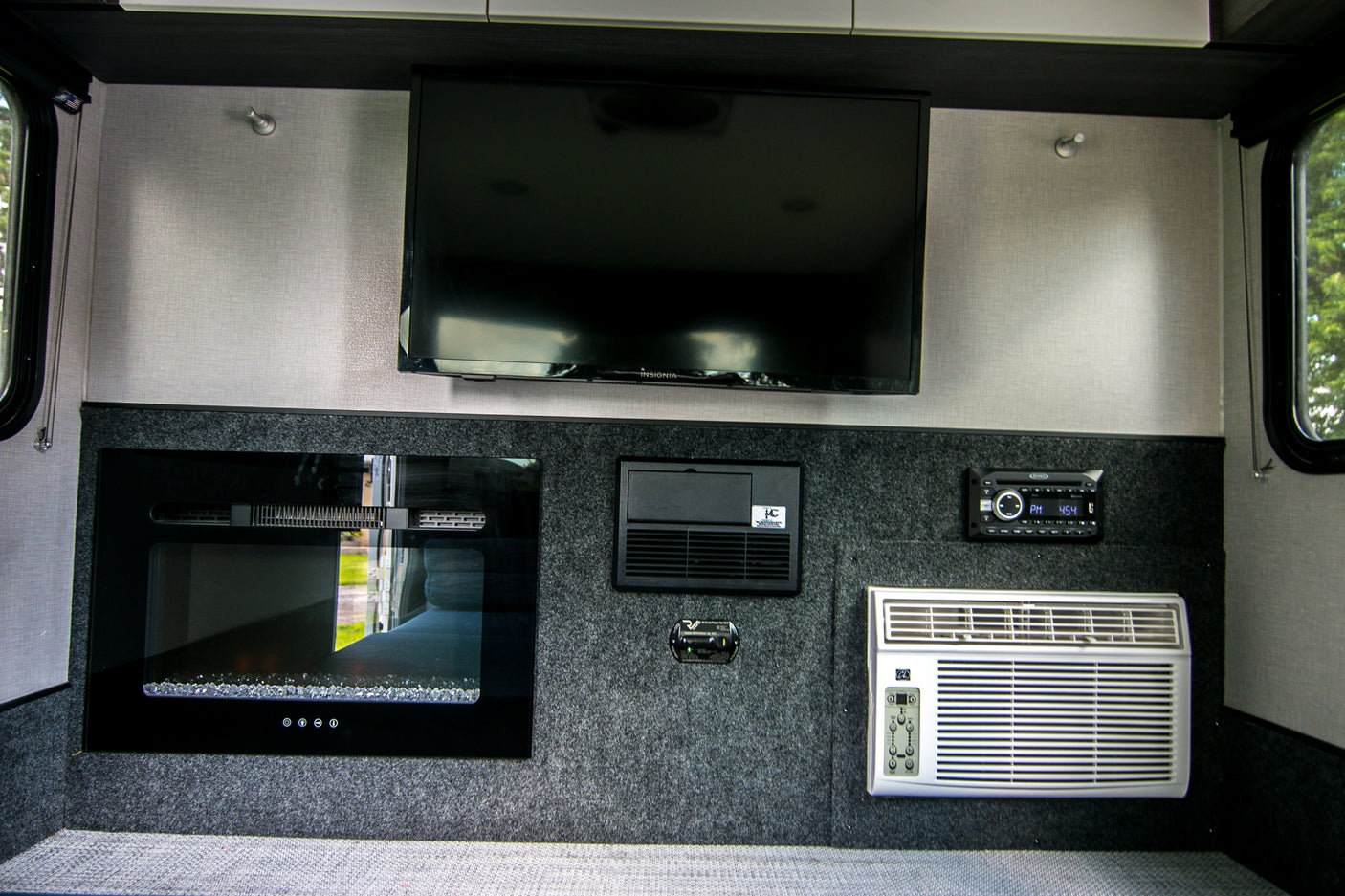 RV rental interior showing TV, electric fireplace, AC, stereo, and power center for a comfortable stay.