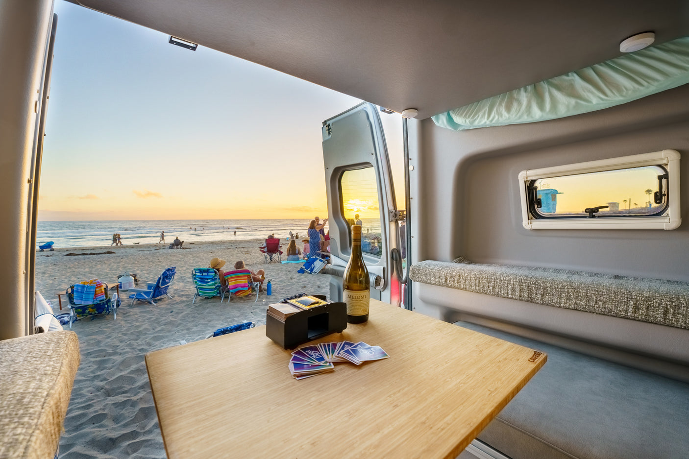 Perfect beach day in your RV rental! Enjoy sunset views, wine, cards, & ocean breeze from your mobile sanctuary.