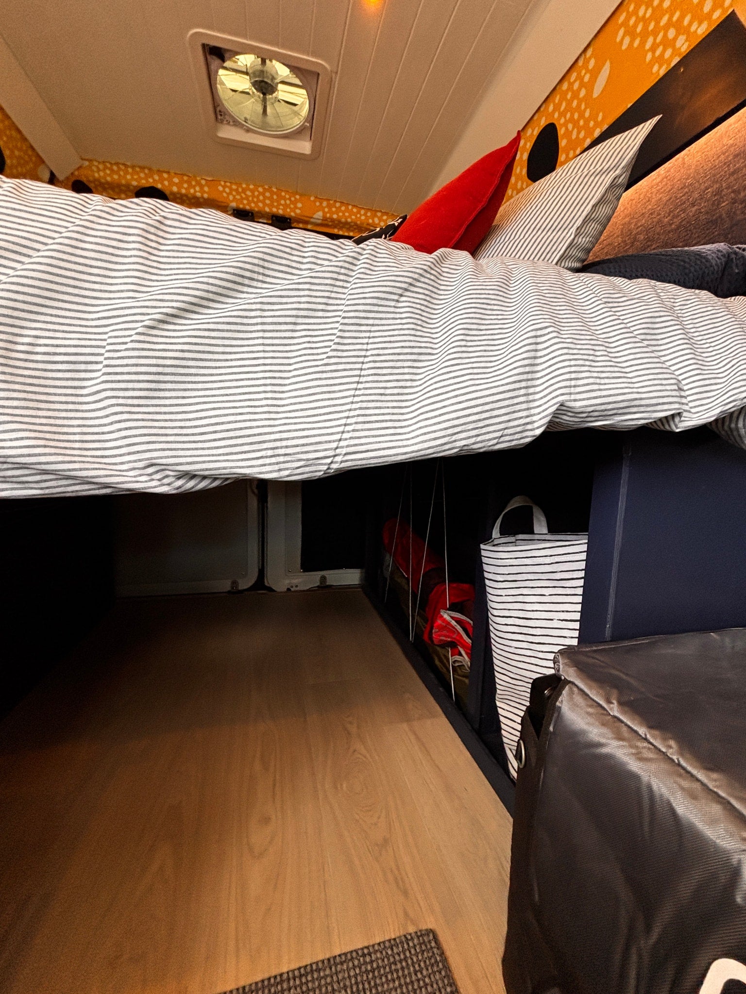 This RV rental offers a comfortable sleeping area with a striped duvet, pillows, and smart under-bed storage for your gear.