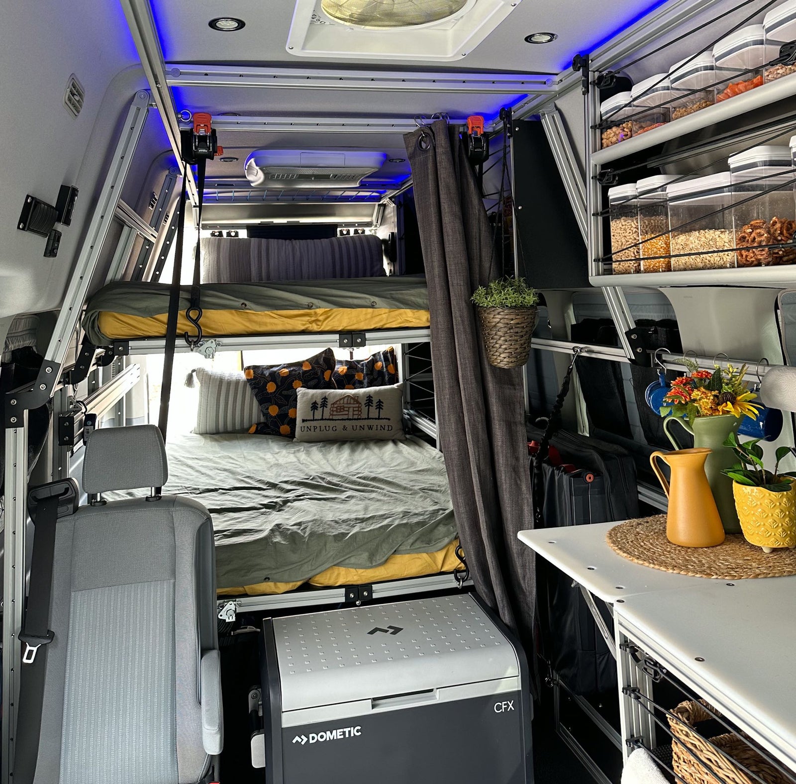 and a vibrant patterned rug.|Modern rv rental interior: suspended bed on aluminum frame