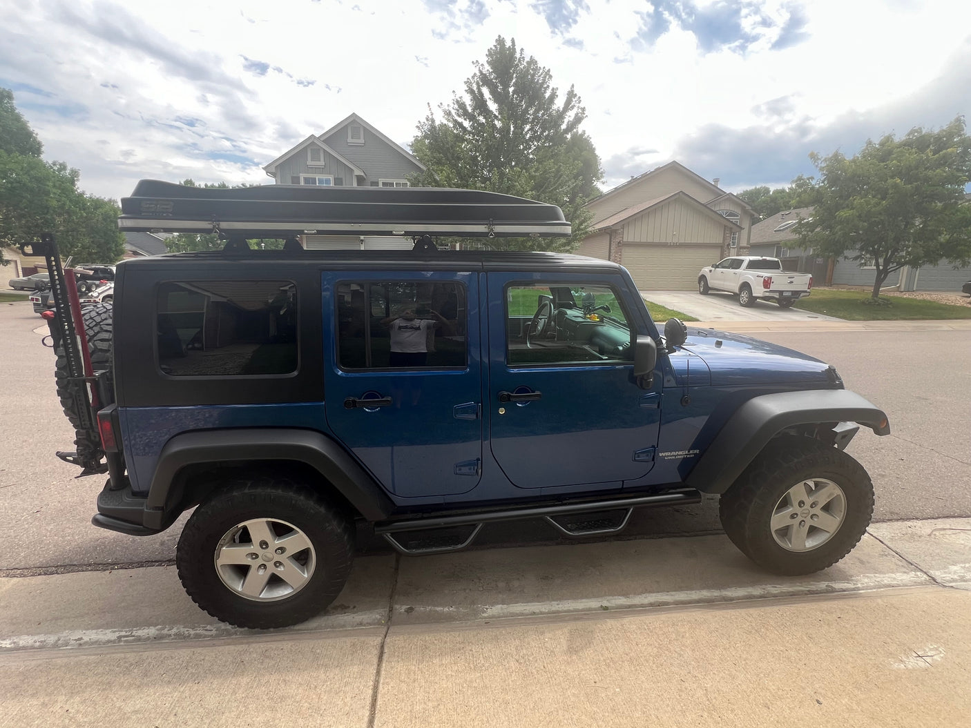 Adventure-ready blue Jeep Wrangler with a rooftop tent, ideal for your next RV rental road trip. Perfect for overland camping!