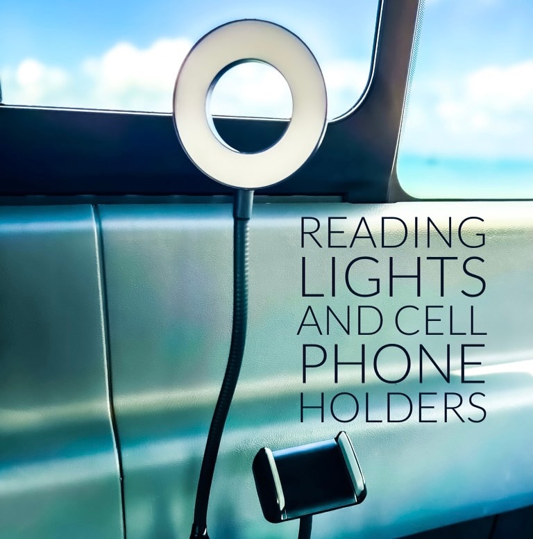 RV rental: A flexible arm with a circular LED reading light & a phone holder mounted inside a modern RV.