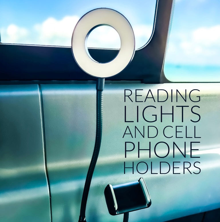 RV rental: A flexible arm with a circular LED reading light & a phone holder mounted inside a modern RV.