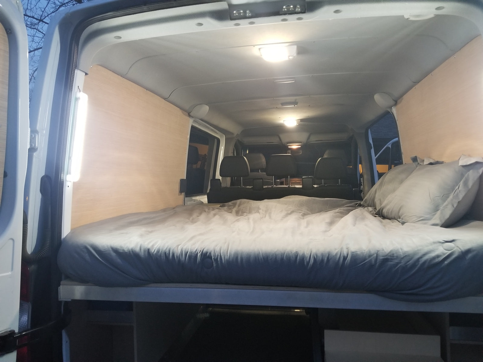 Cozy RV rental interior featuring a comfortable bed and wood paneling, ideal for road trips.