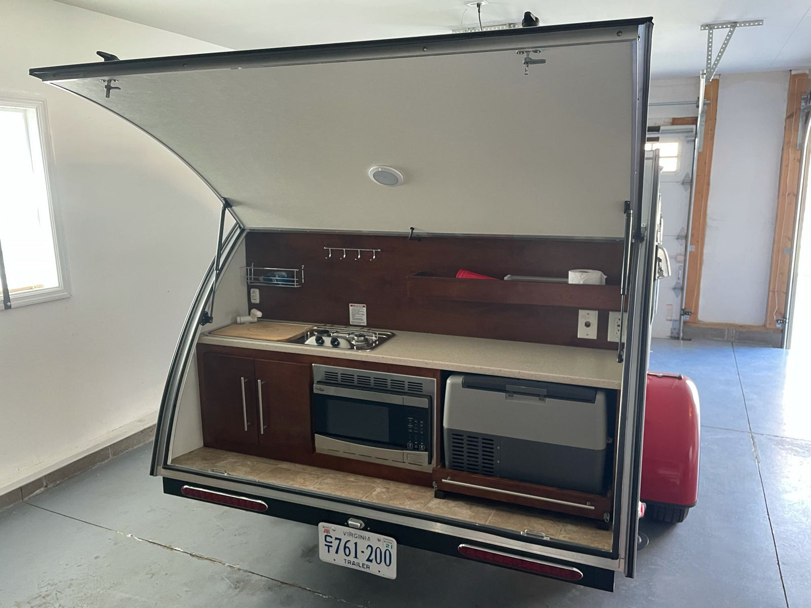 and wood cabinets.|Compact & cozy RV rental interior: spacious bed