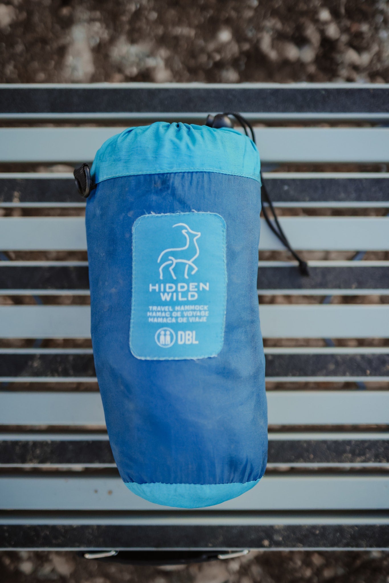 A blue Hidden Wild double travel hammock, neatly packed in its stuff sack on a slatted surface. Ideal for any RV rental trip. — photo 9