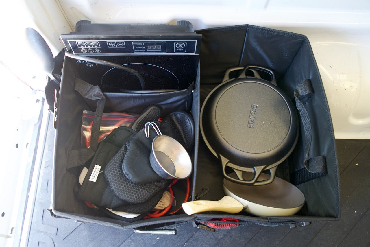 Portable RV rental kitchen setup: induction cooktop, cast iron pan, and cooking essentials for camping.