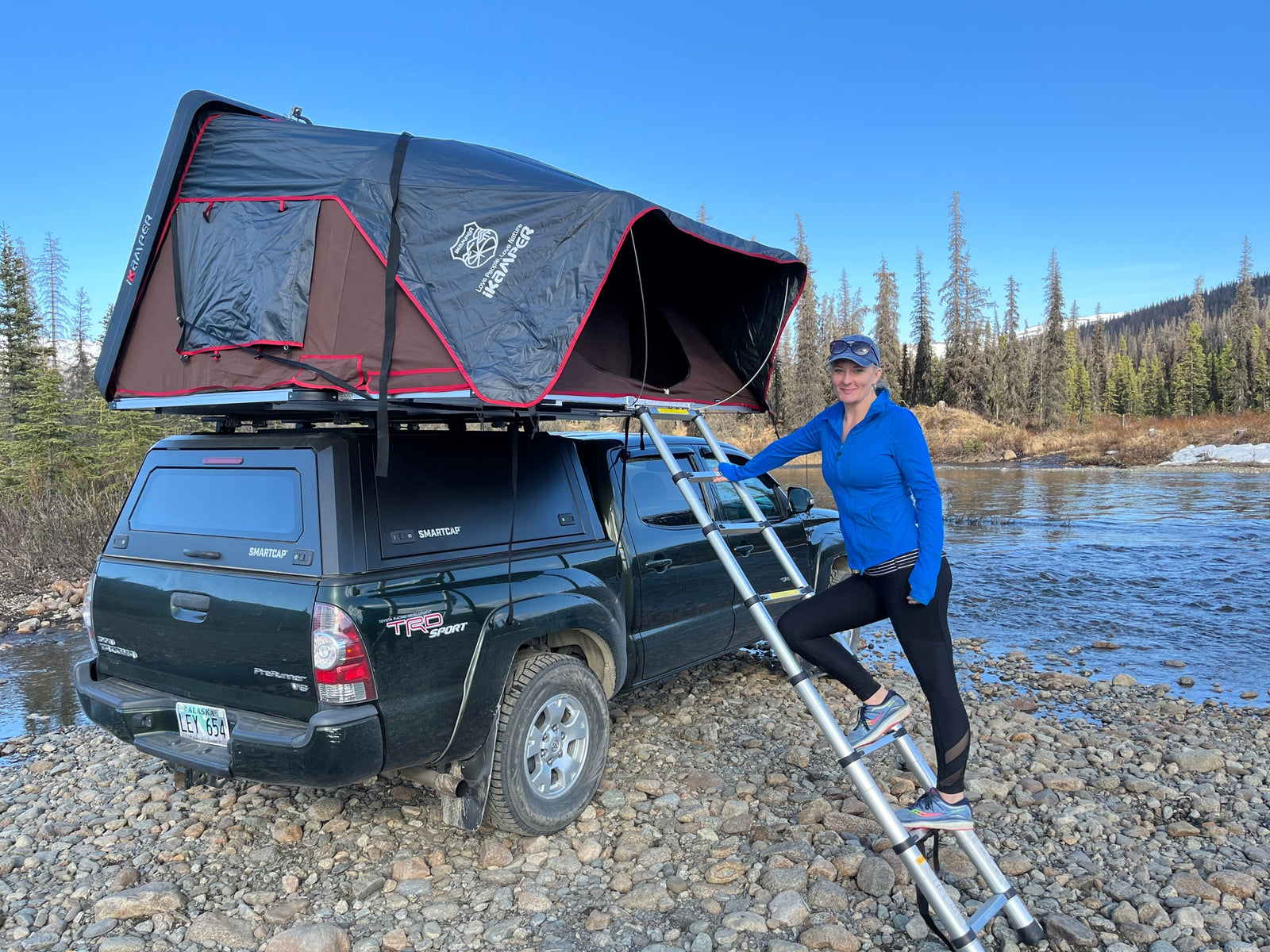 Exploring nature with an iKamper rooftop tent on a Toyota Tacoma by a scenic river. A great RV rental alternative for outdoor travel.