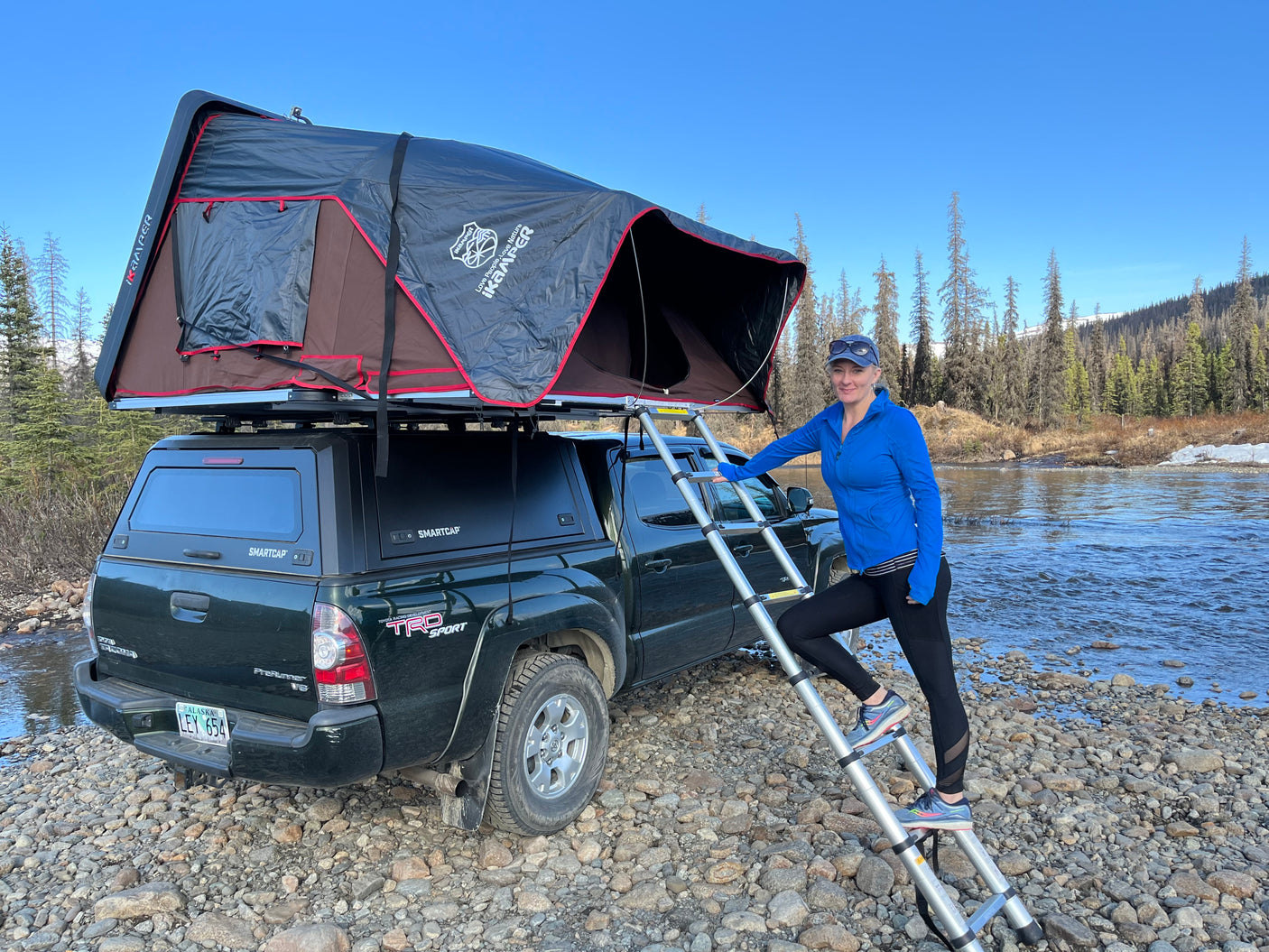 Exploring nature with an iKamper rooftop tent on a Toyota Tacoma by a scenic river. A great RV rental alternative for outdoor travel.