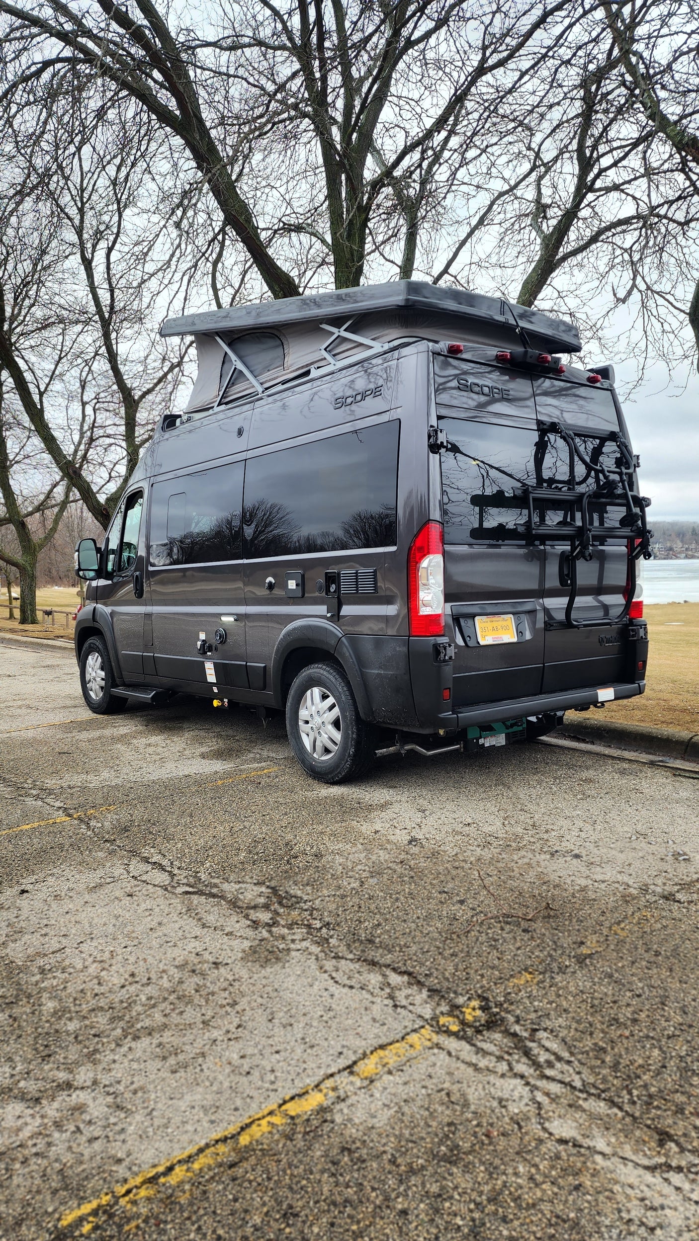 This dark gray Scope pop-top camper van with bike rack makes a great rv rental for scenic trips by the water.