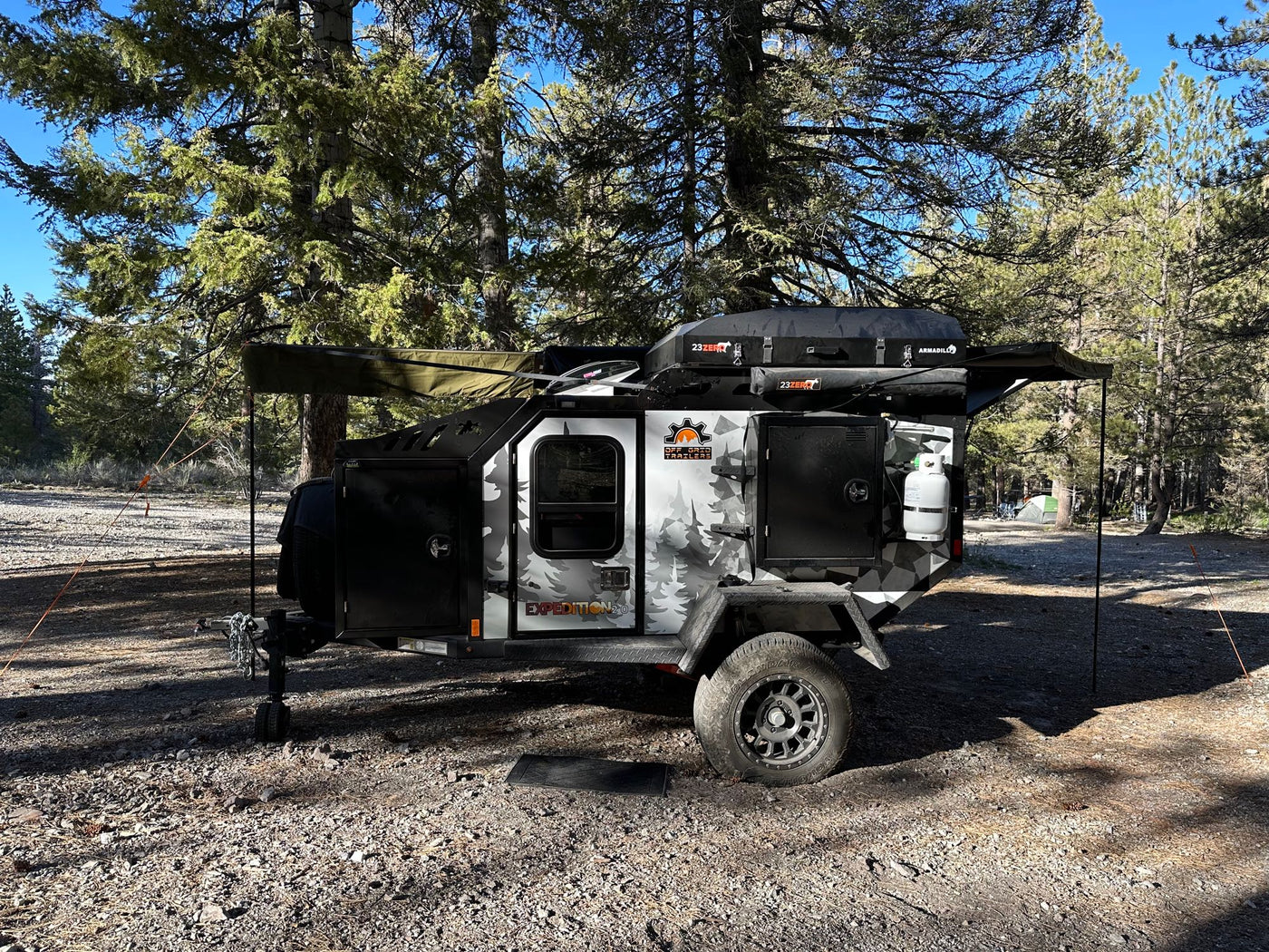 Rugged off-road expedition camping trailer in a sunny forest. Ideal RV rental for adventure. — photo 13