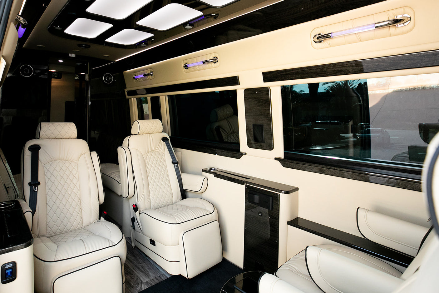 Plush interior of a luxury RV rental, featuring custom leather seating, ambient lighting, and wood accents.
