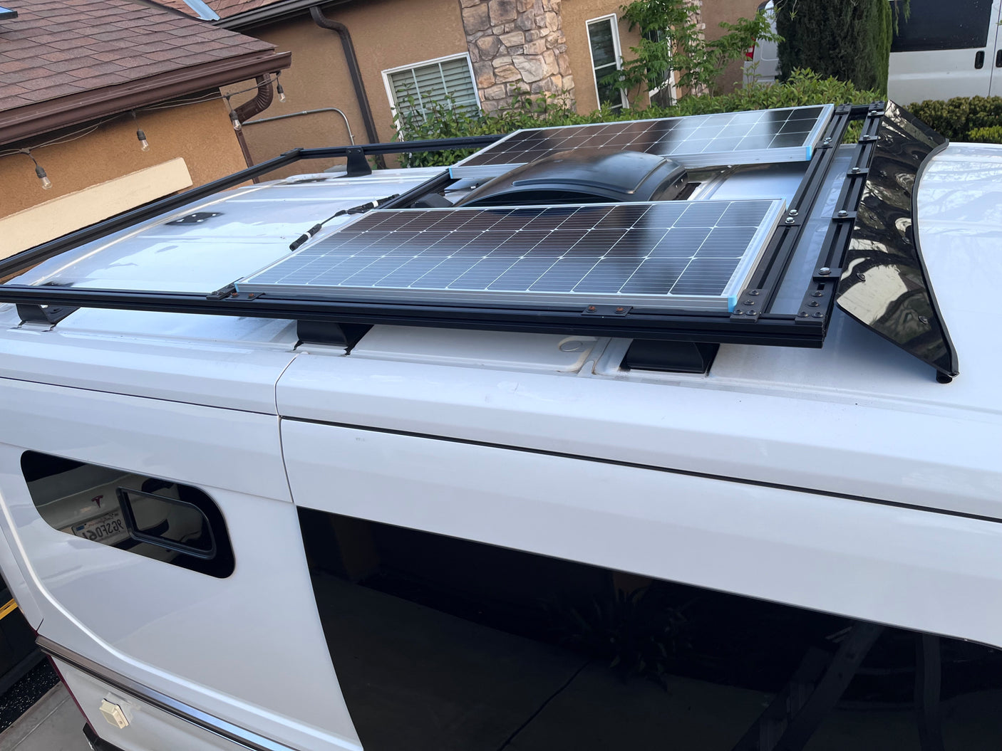 This white RV rental showcases two rooftop solar panels and a central vent system, ideal for off-grid adventures.