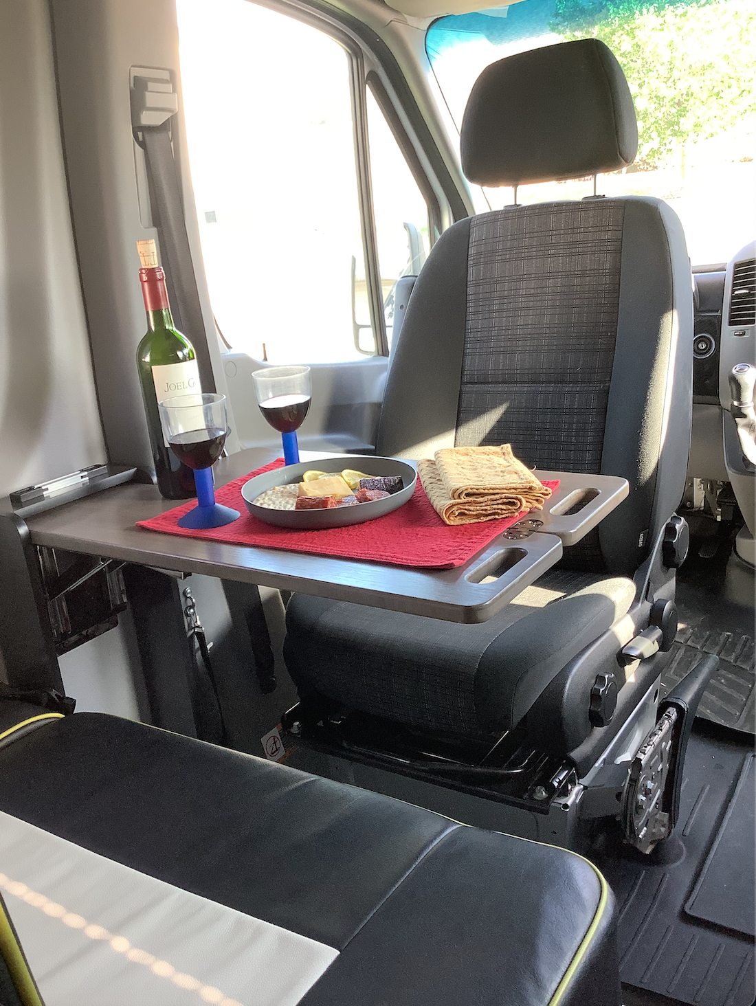 Cozy RV rental interior with a charcuterie board, wine, and two glasses set for dining.