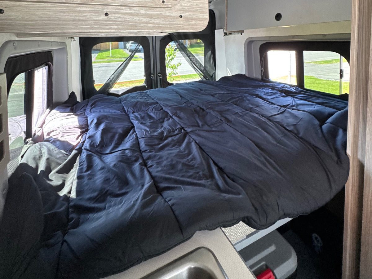 perfect for outdoor adventure.|Cozy RV rental bed with an ocean view through the mesh screen. Perfect for a scenic campervan travel experience.|Cozy RV rental bed with a dark blue comforter — photo 6