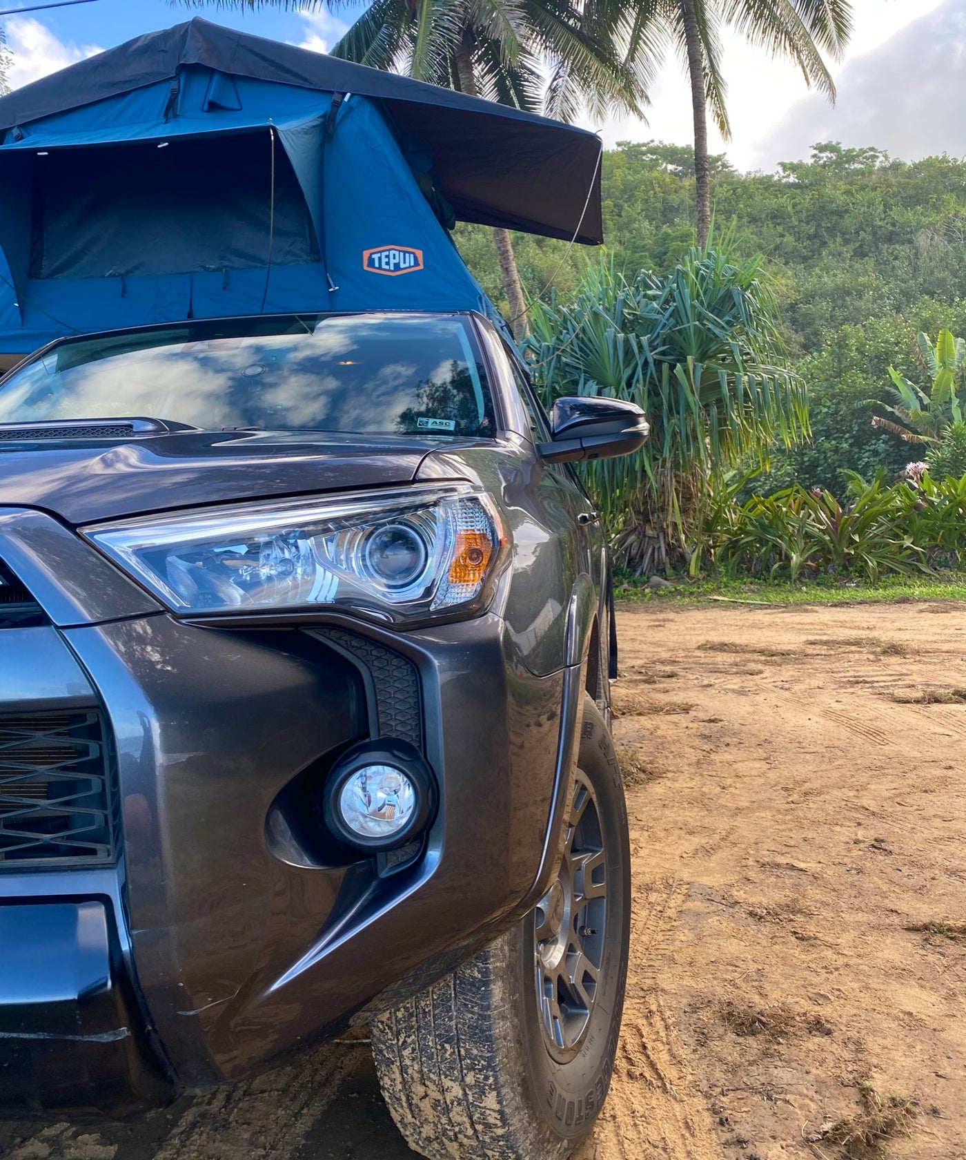 Gray SUV with blue Tepui rooftop tent, a rugged RV rental option for wilderness camping on a dirt road. — photo 18