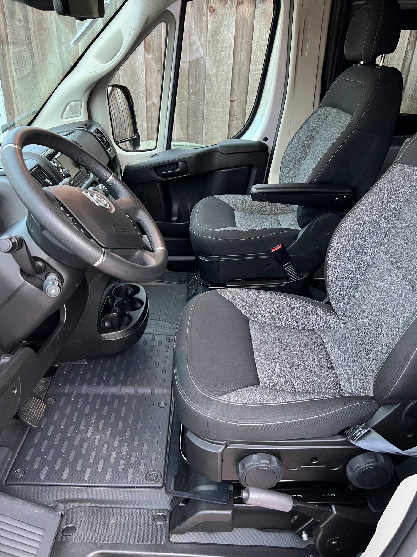 Spacious RV rental cabin, showing the steering wheel, dashboard, and two comfortable front seats, perfect for road trips.