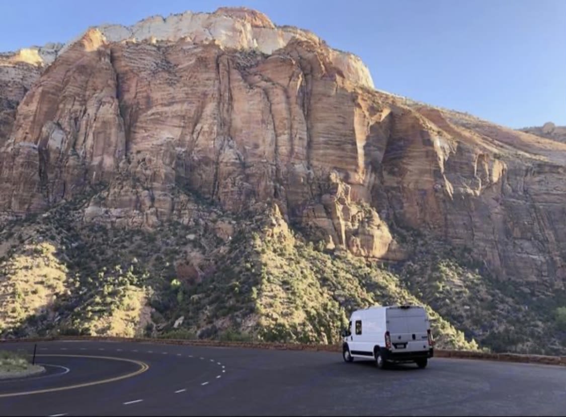 dog-friendly space. Perfect for your next RV rental adventure!|Cozy rv rental moments: A person sips coffee on a striped bed