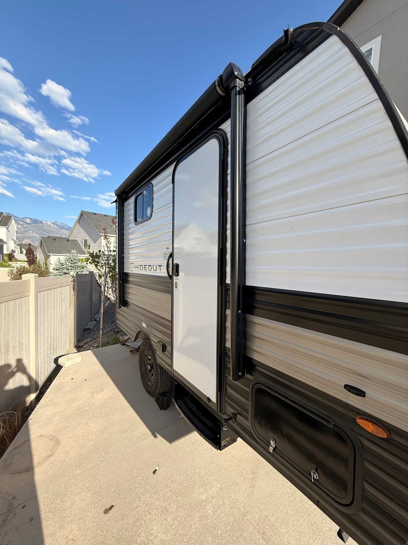 This "Hideout" RV rental, a travel trailer, is parked on a sunny concrete driveway. — photo 3