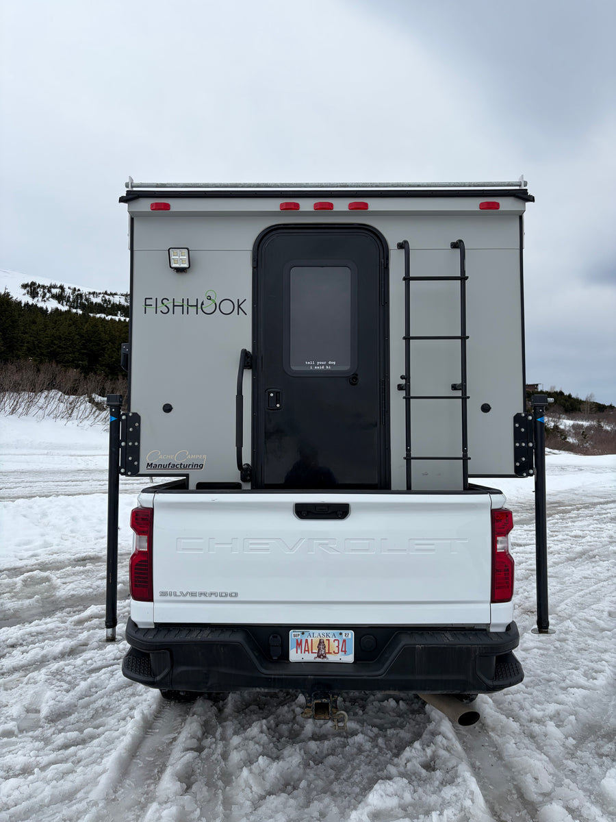 is ready for snowy mountain adventures.|White Chevrolet truck camper