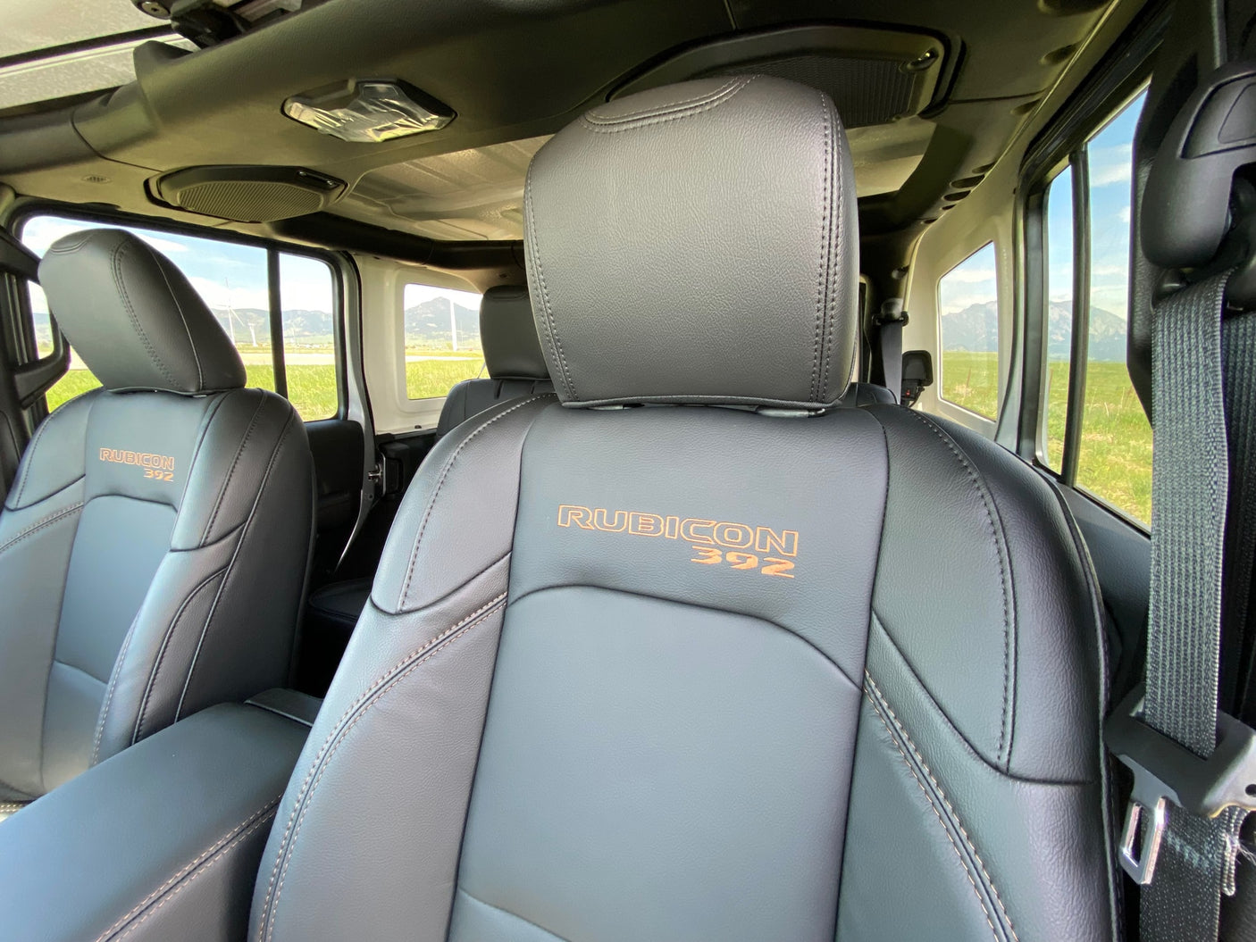 Inside a Jeep Rubicon 392: Black leather seats, mountain view. Perfect for an adventurous RV rental.