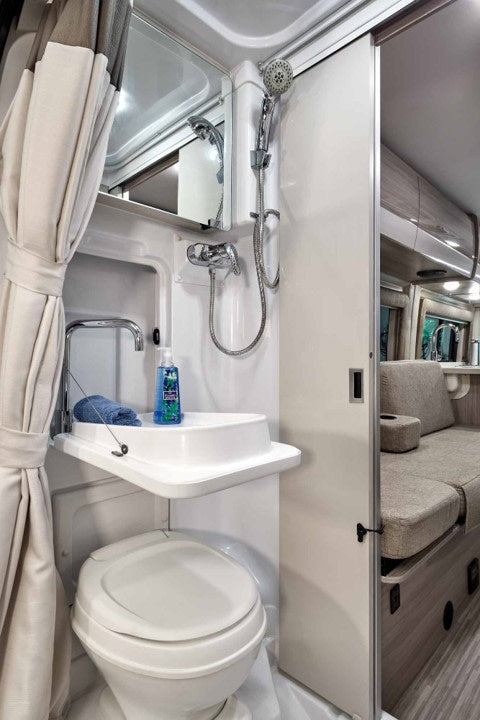 & scenic window views.|Cozy RV rental sleeping area featuring two twin beds with white linens