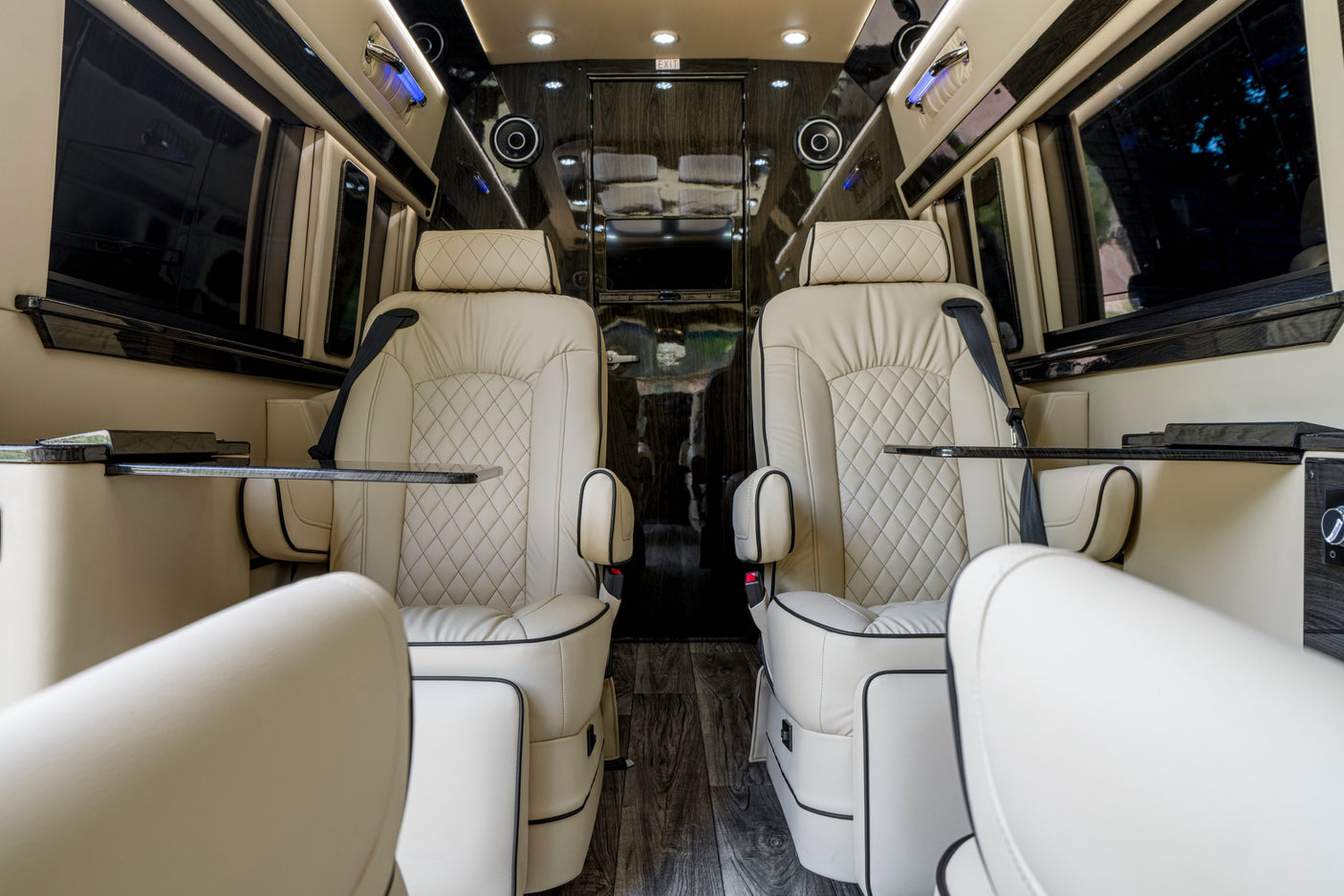 Luxury RV rental interior: spacious cabin with premium cream captain's chairs and dark wood accents for comfortable travel.