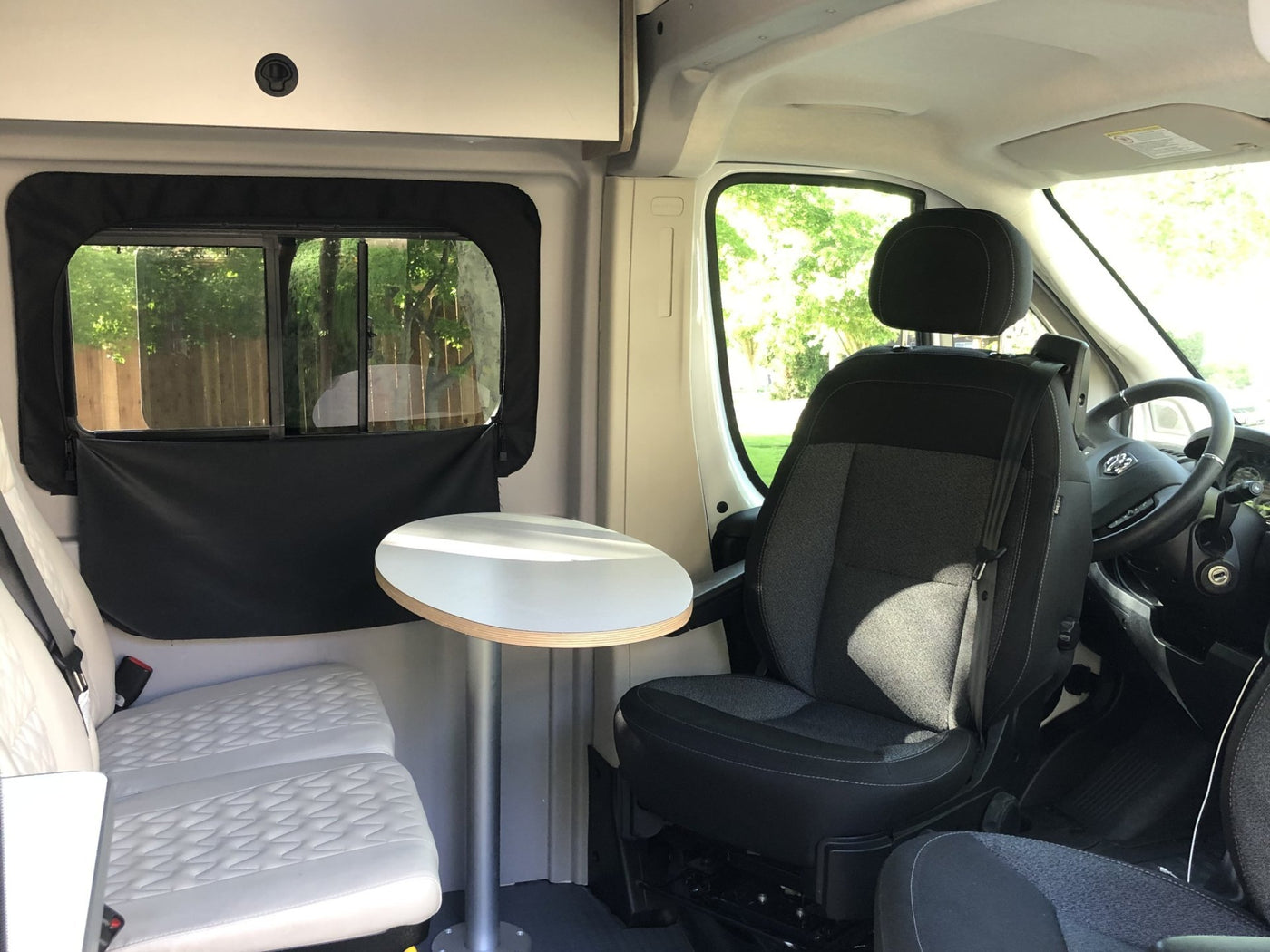 is parked in a scenic grassy area surrounded by trees for a peaceful camping experience.|Inside an RV rental: a compact wet bath featuring a toilet — photo 3
