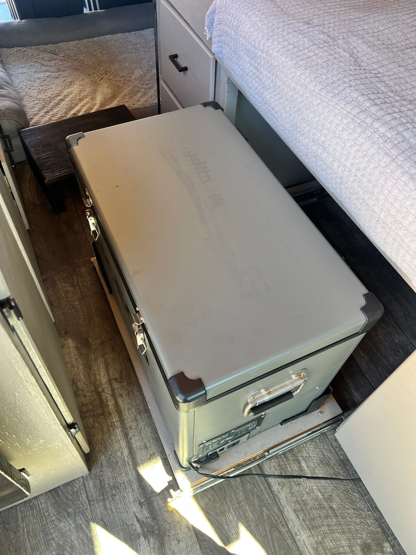 This rv rental features a convenient portable fridge on a slide-out tray, providing easy access to cold storage under the bed.