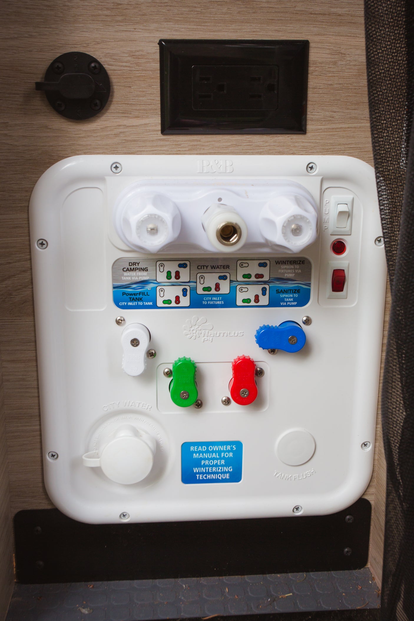 RV rental: White control panel for an RV's water system, showing settings for dry camping, city water, tank fill, winterize, and sanitize.