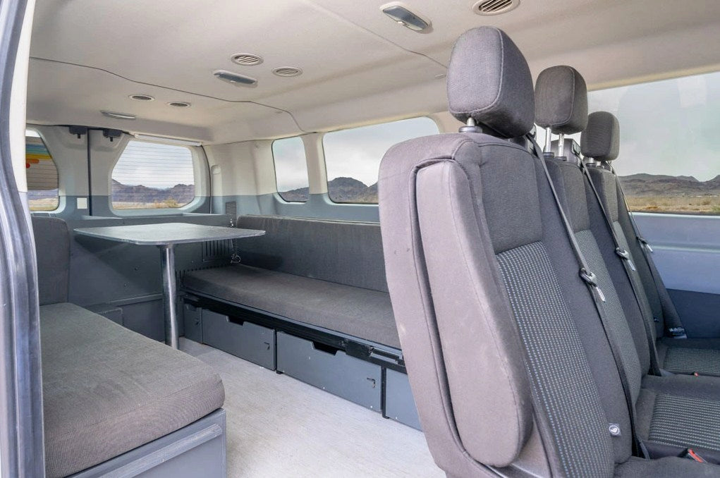 looking out to a vast lake and distant mountains.|This RV rental shows a compact campervan kitchen with sink — photo 4