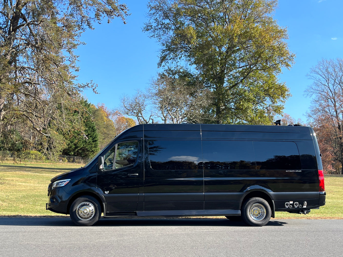 Black Mercedes-Benz Sprinter conversion van parked outside, ideal for luxury RV rental getaways under blue skies.