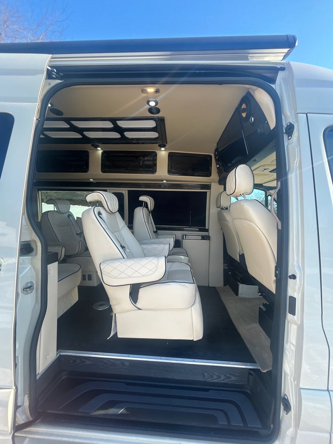 showcasing its plush interior with a view of other RVs outside.|RV rental: Compact camper van interior featuring a toilet
