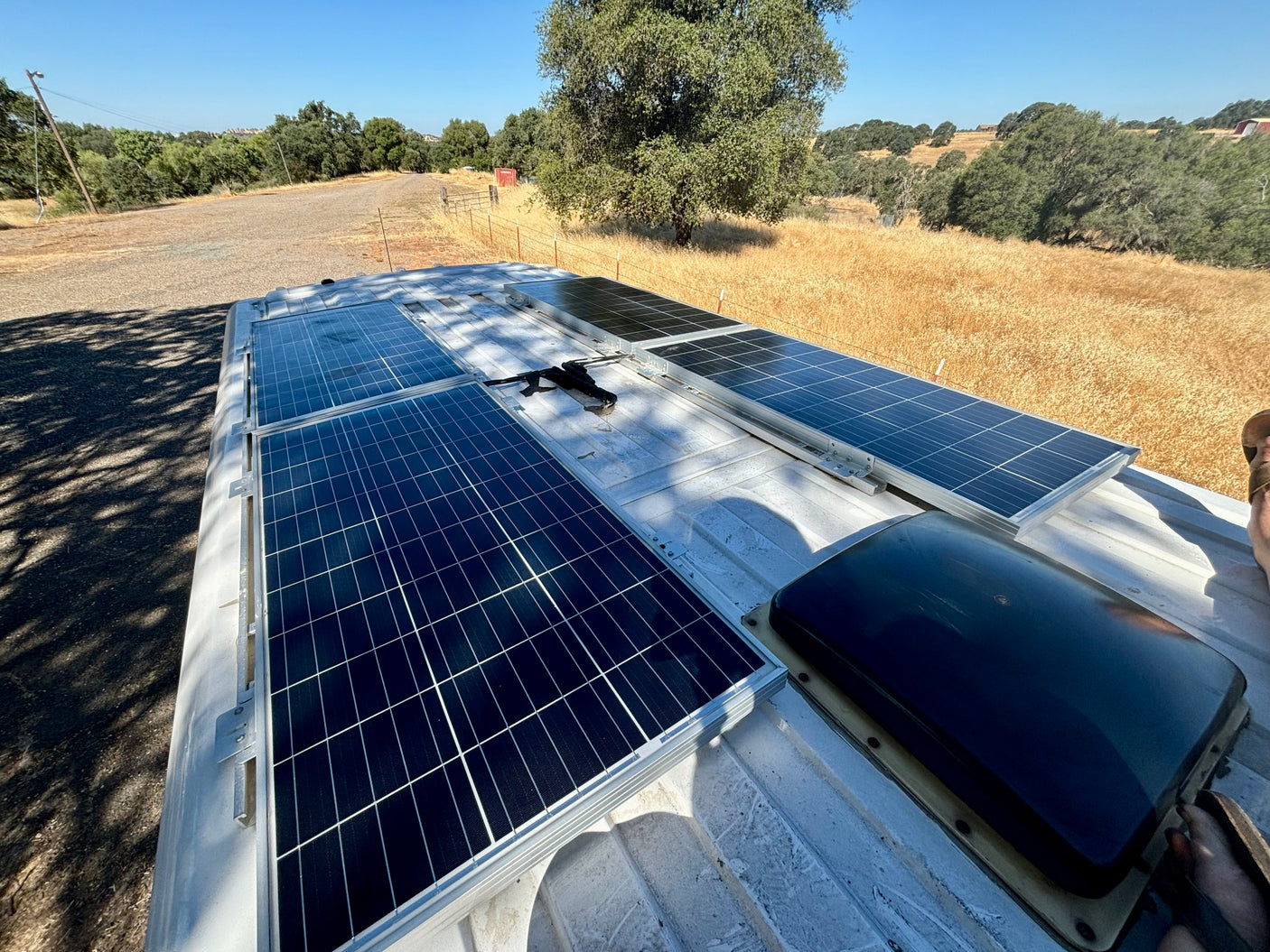 Rooftop solar panels on an RV rental provide off-grid power, ideal for adventures in this sunny rural setting.