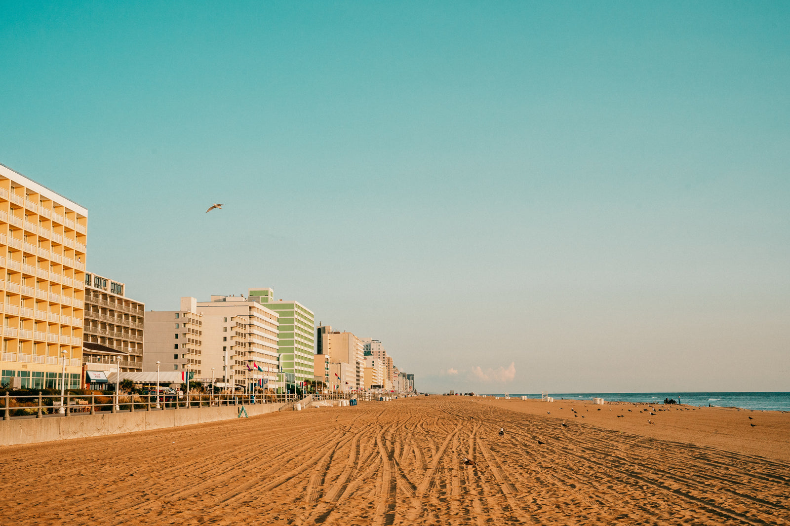 Vast sandy beach stretching along a coastline dotted with hotels and the ocean, perfect for an RV rental escape.