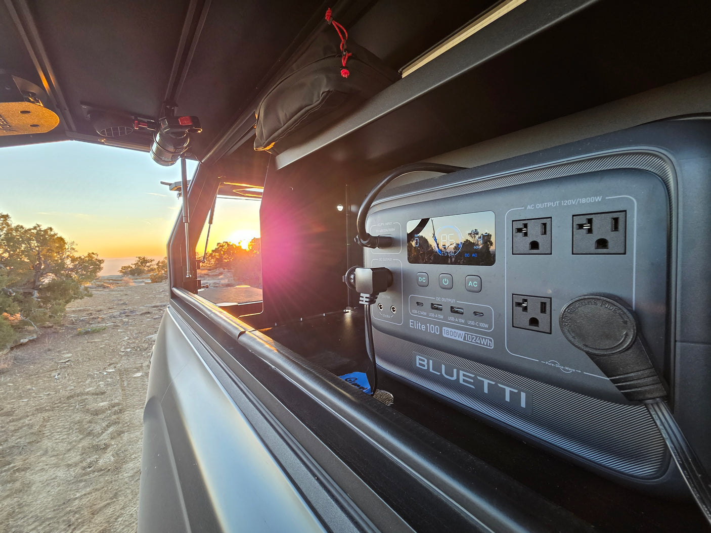 A Bluetti Elite 100 power station in an RV rental's truck bed setup, powering off-grid adventures at sunset.