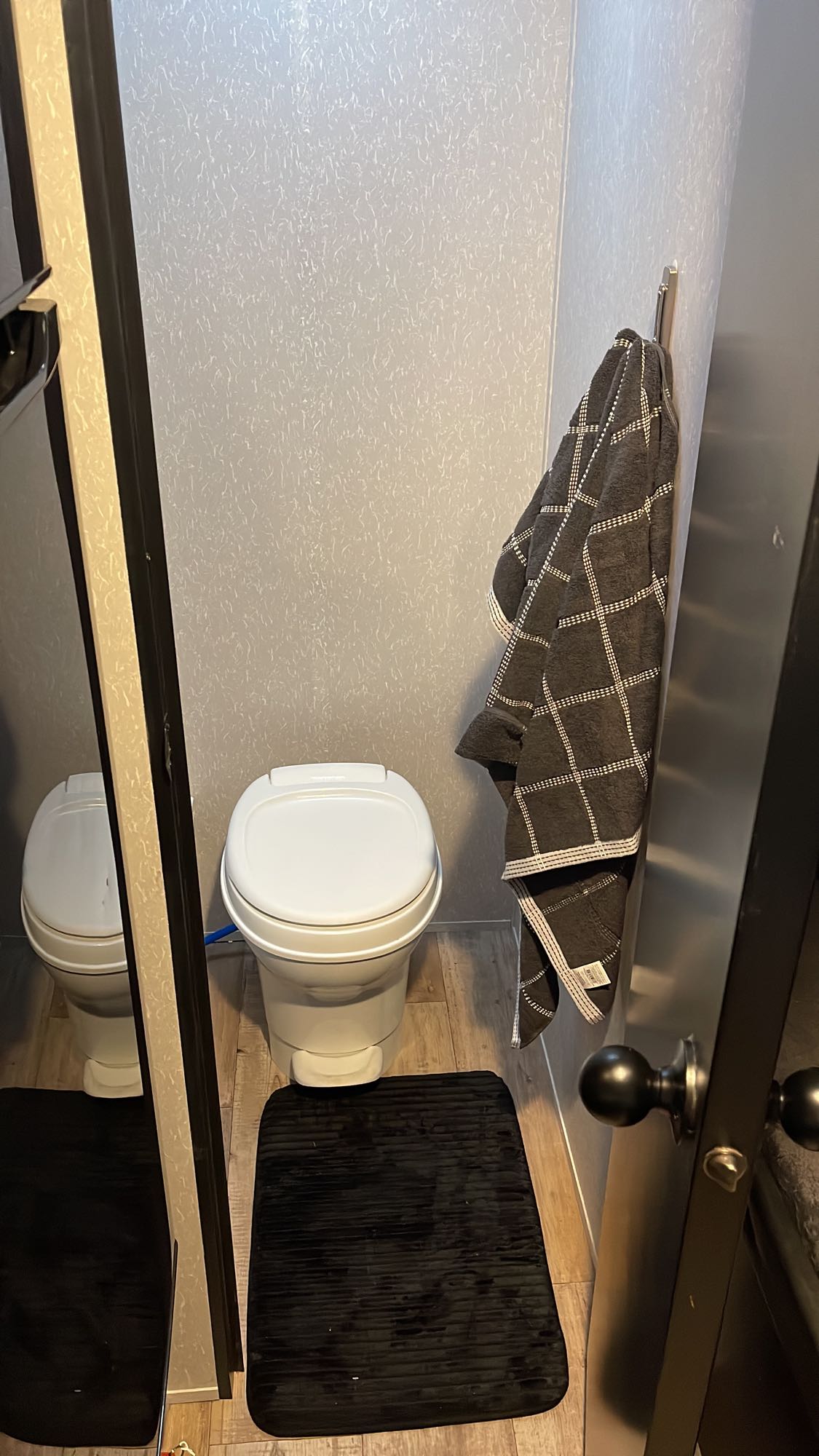 an RV rental option. Sunny day in lot with other RVs.|Explore this RV rental's interior: kitchen with microwave