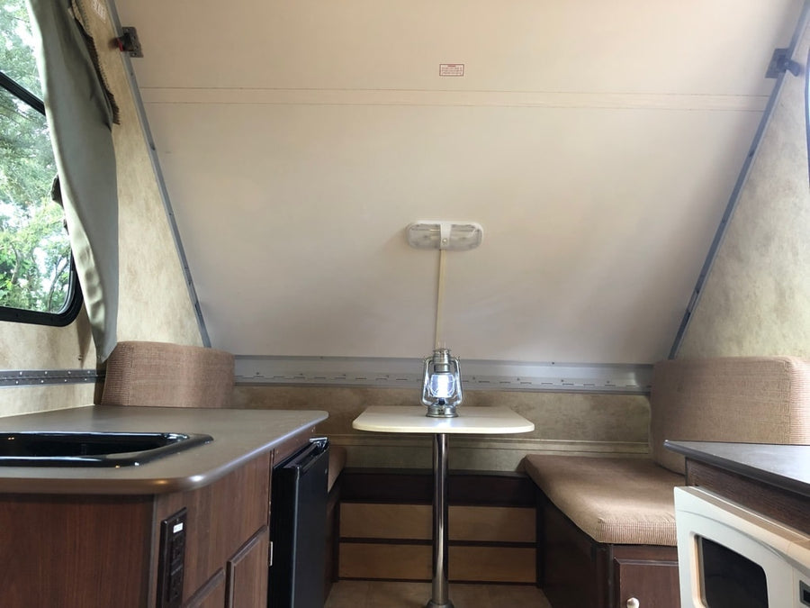parked outdoors.|White A-frame Scout travel trailer