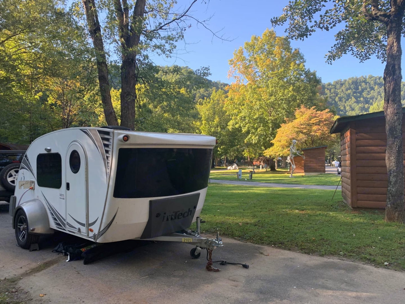 RV rental: a white teardrop trailer at a scenic fall campsite