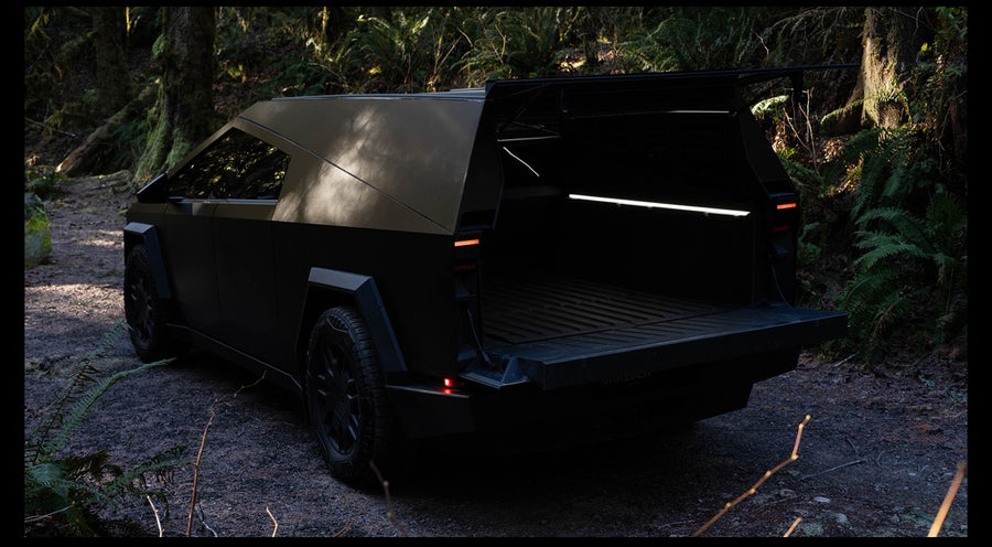 Open camper shell on an electric Tesla Cybertruck in a forest, tailgate down. Great for your next RV rental adventure.