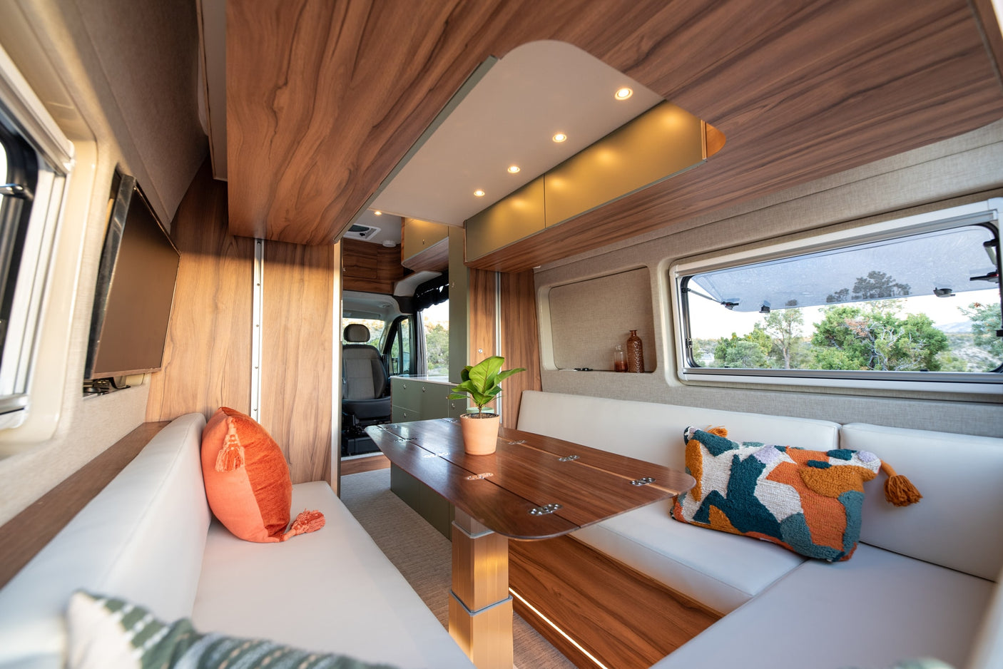 Experience comfort in this rv rental's modern interior, featuring a bright dining area, plush seating, and scenic window views.