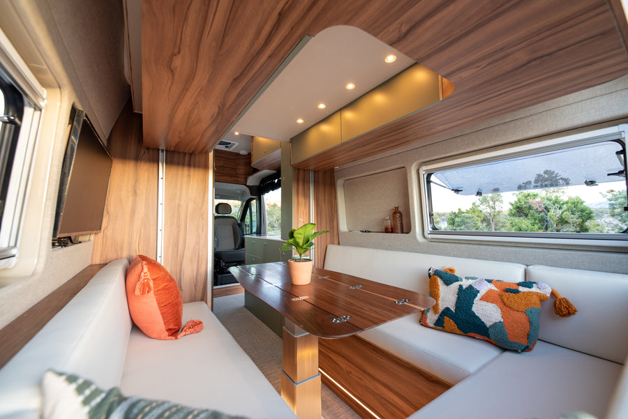 Experience comfort in this rv rental's modern interior, featuring a bright dining area, plush seating, and scenic window views.