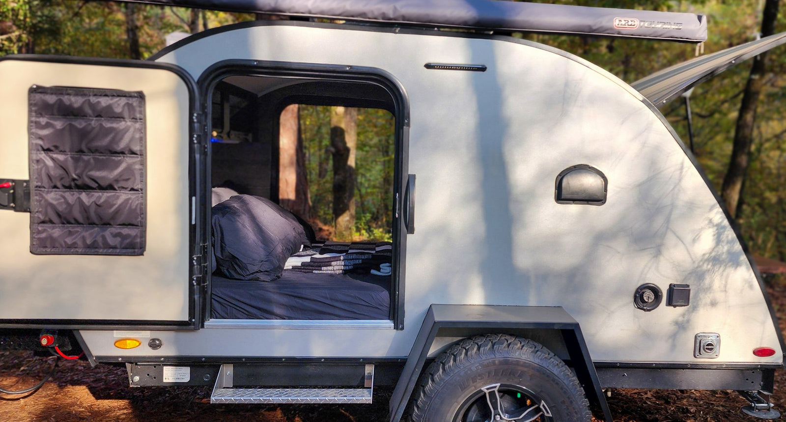 and storage cabinets over a bed with rustic decor.|Cozy RV rental interior with vibrant blue LED lighting