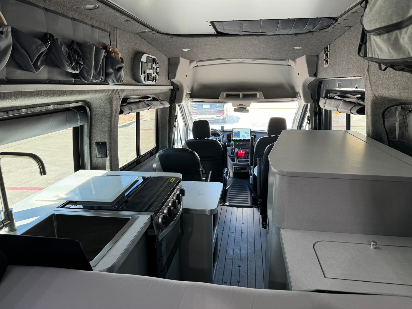 featuring all-terrain tires & rear ladder.|Grey ModVans Ford Transit camper van with off-road tires — photo 10