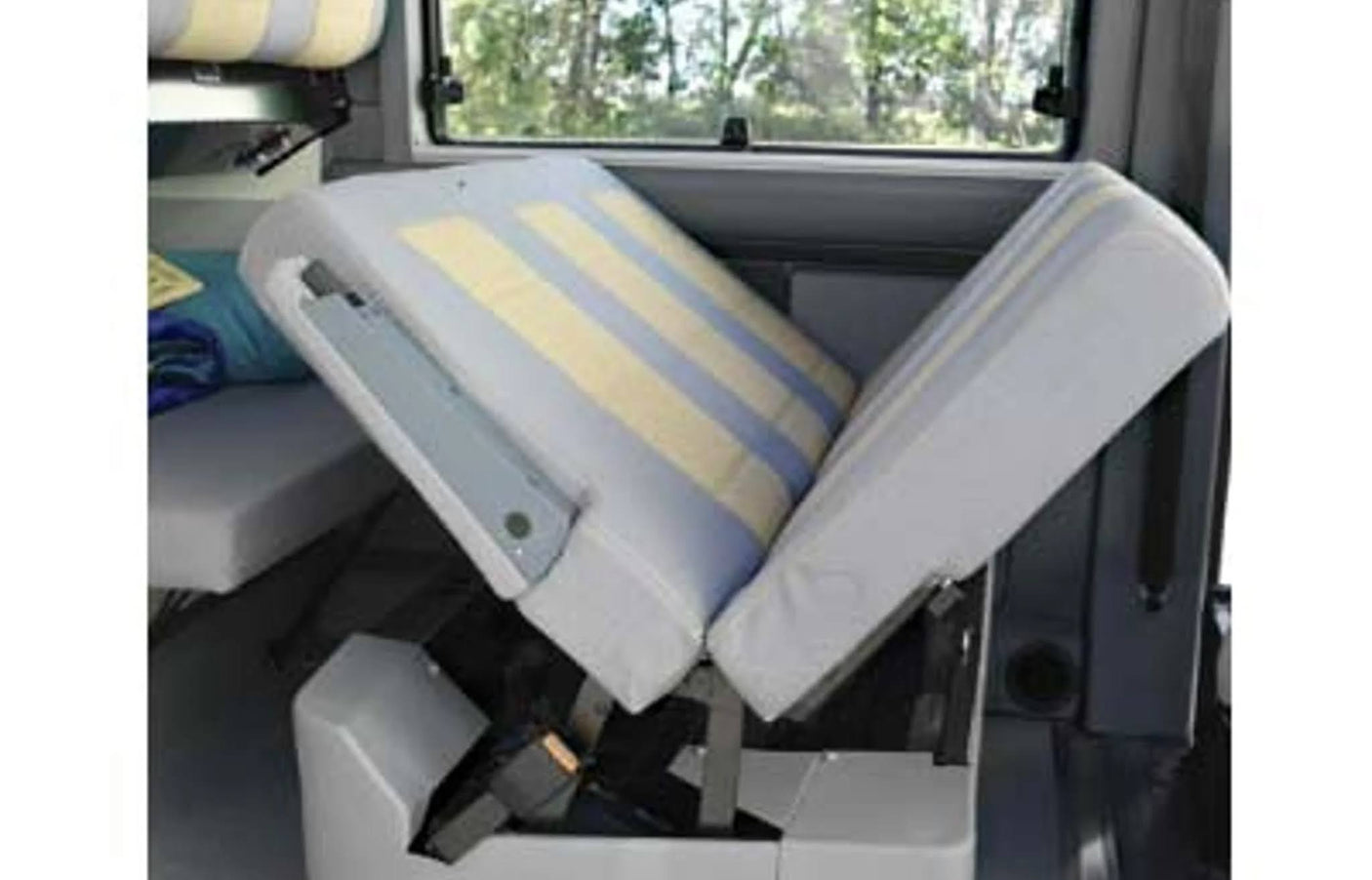 RV rental camper van's convertible bed/seat. Striped cushions are partially folded, revealing adaptable interior space.