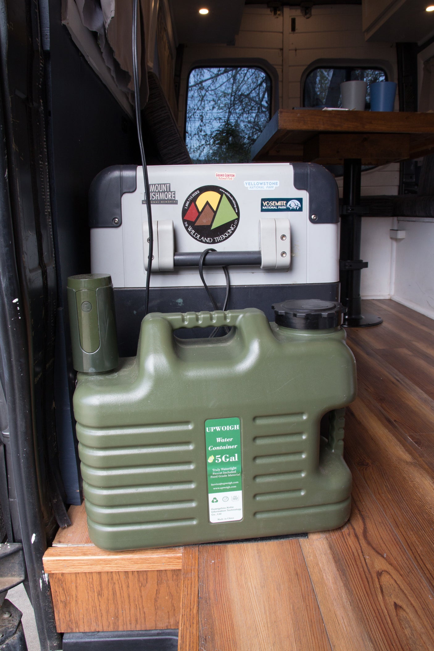 RV rental with camping essentials: a large cooler, 5-gallon water container, and gear for national park adventures.