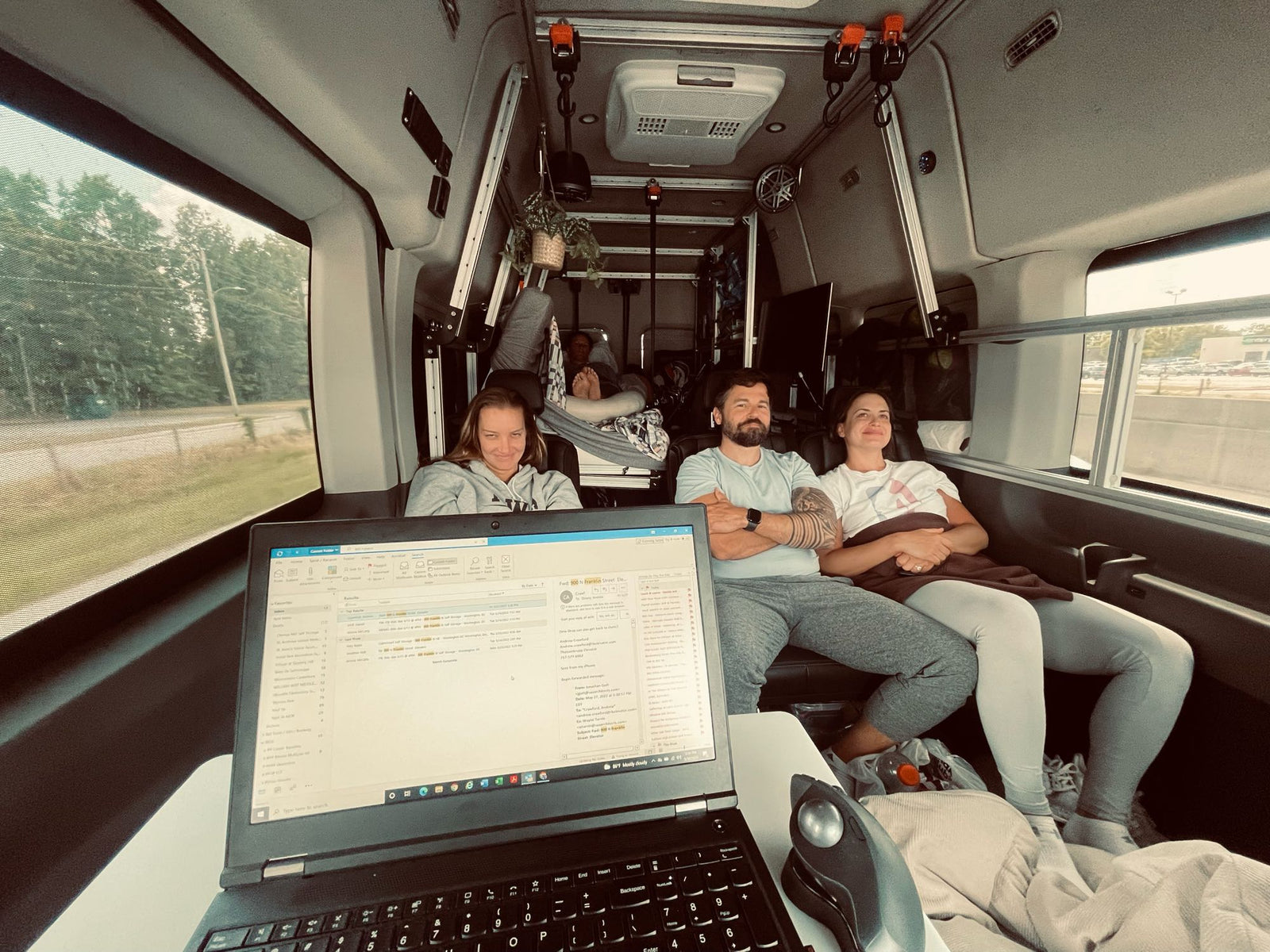 RV rental interior: Four people relaxing and working on a laptop in a cozy mobile office.